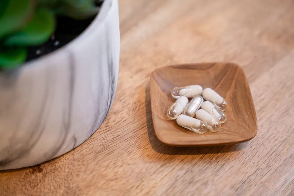 Probiotic capsules in a small wooden dish